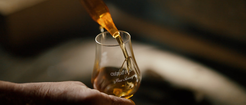 Photo d'une pipette servant un verre d'Armagnac du château de Lacquy