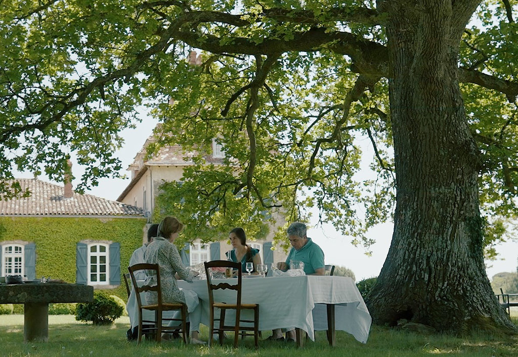 Vue du Château de Lacquy avec des personnes en train de déjeuner symbolisant le savoir vivre à la Française 